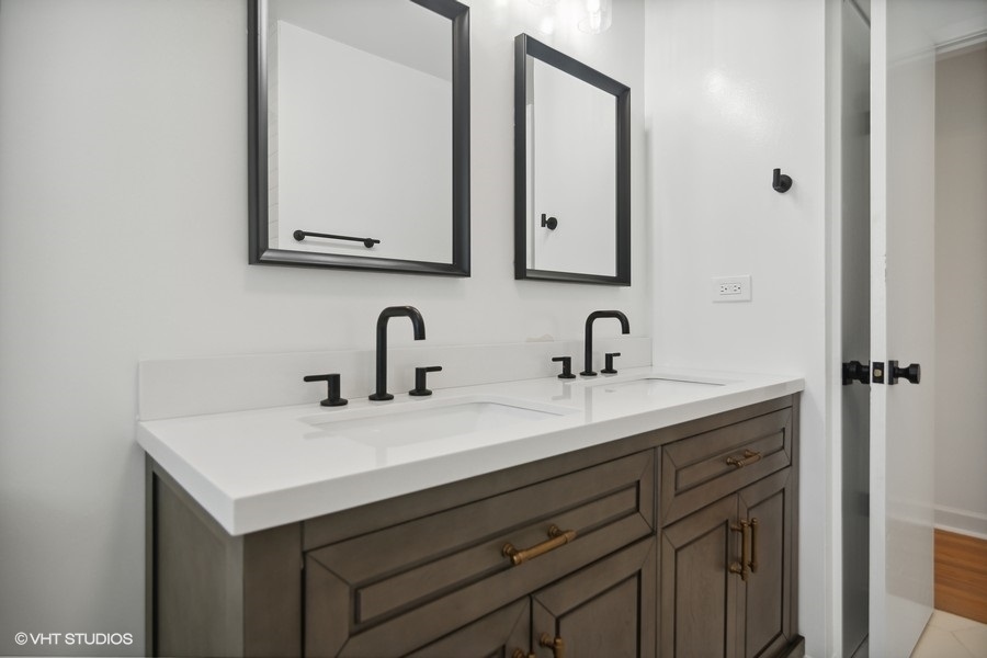 Updated bathroom with double vanity and framed mirrors
