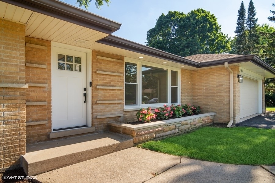 Covered front entry with new white door and stone planter