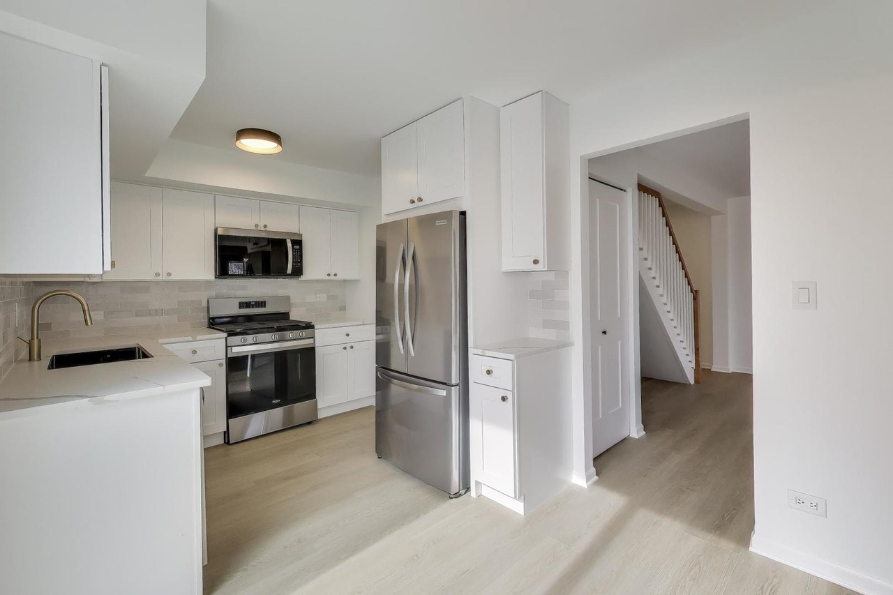 White shaker kitchen with quartz counters and stainless appliances